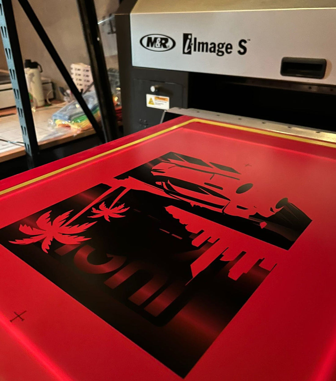 Screen printing mesh screens being prepared for a multi-colour design on custom apparel